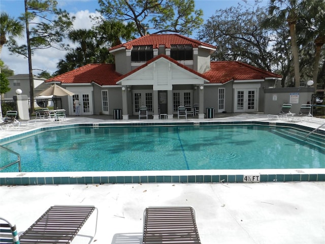 view of pool featuring french doors, a patio, and central AC unit