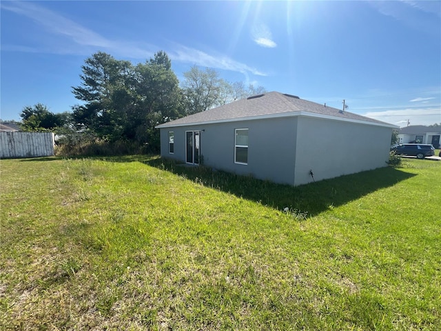 view of side of home with a yard