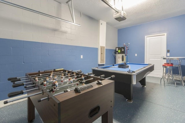 playroom featuring a textured ceiling, electric panel, billiards, and water heater