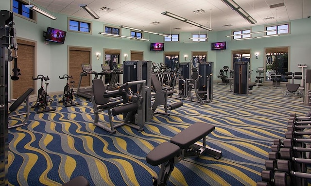 gym with a high ceiling and carpet floors