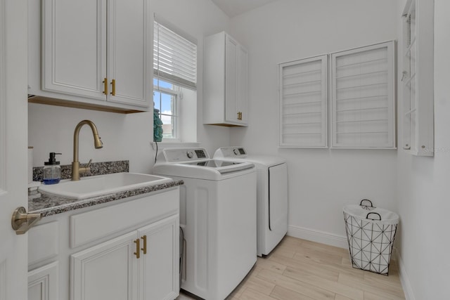 washroom with washer and clothes dryer, cabinets, light wood-type flooring, and sink