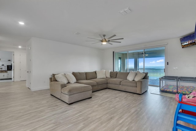 living room with light hardwood / wood-style floors and ceiling fan