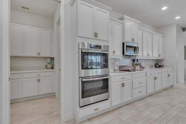 820 Windlass Ct, Kissimmee, FL 34746 - kitchen featuring light countertops, appliances with stainless steel finishes, wood finish floors, and decorative backsplash