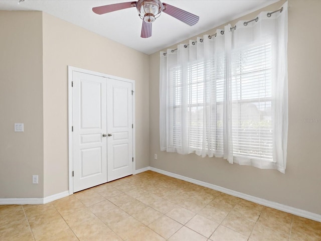 unfurnished bedroom with a closet, ceiling fan, and light tile patterned flooring