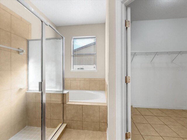 bathroom featuring a baseboard radiator, tile patterned floors, and plus walk in shower