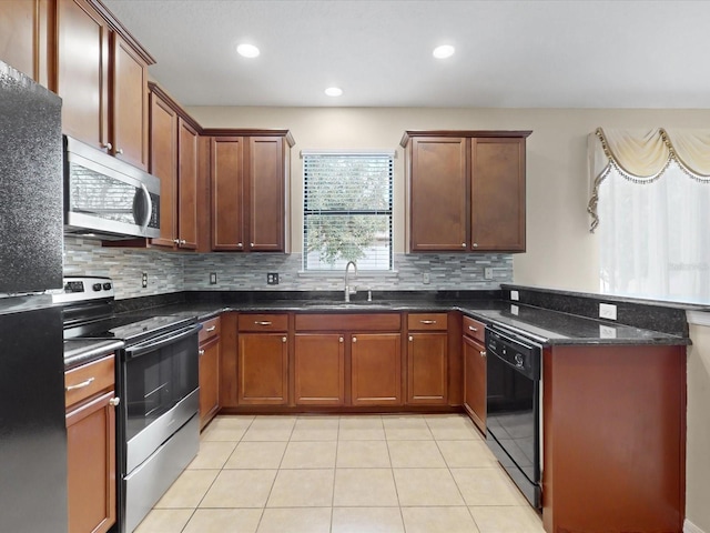 kitchen with sink, light tile patterned floors, tasteful backsplash, black appliances, and dark stone counters