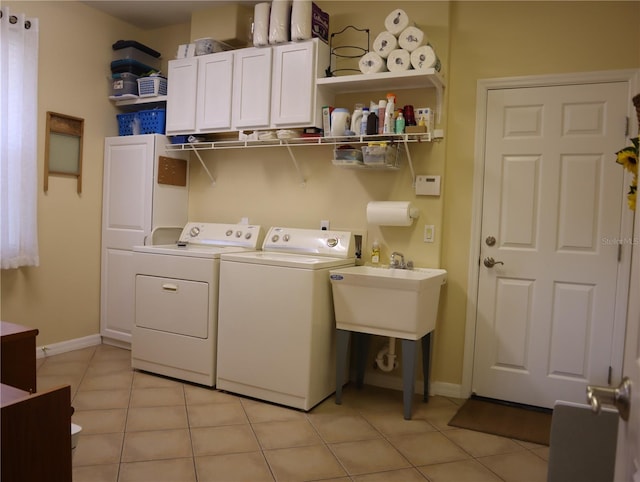 laundry room featuring light tile patterned floors, sink, independent washer and dryer, and cabinets