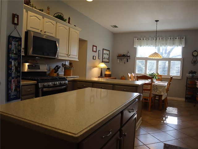 kitchen featuring a notable chandelier, light tile patterned floors, appliances with stainless steel finishes, and decorative light fixtures