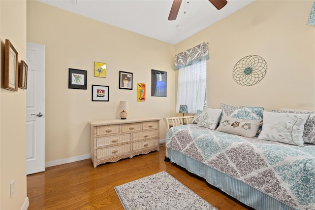 bedroom with ceiling fan, baseboards, and wood finished floors