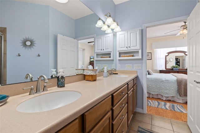 full bath featuring double vanity, connected bathroom, a sink, and tile patterned floors