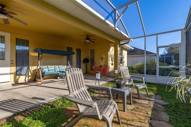 view of patio with a ceiling fan and glass enclosure