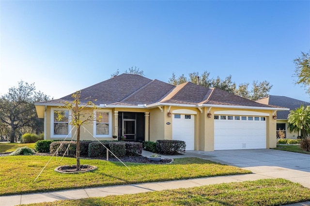 ranch-style home with a garage, driveway, a front lawn, and stucco siding