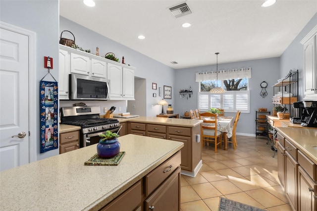 kitchen featuring visible vents, white cabinets, appliances with stainless steel finishes, a peninsula, and light countertops