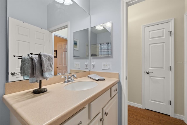 bathroom with vanity, baseboards, and wood finished floors