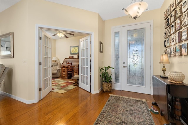 foyer with ceiling fan, baseboards, wood finished floors, and french doors