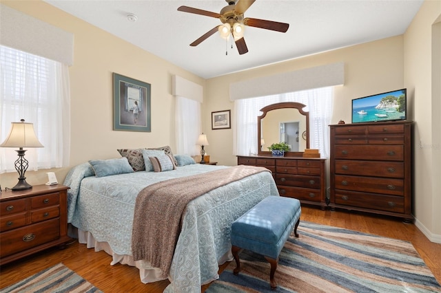 bedroom featuring ceiling fan, wood finished floors, and baseboards