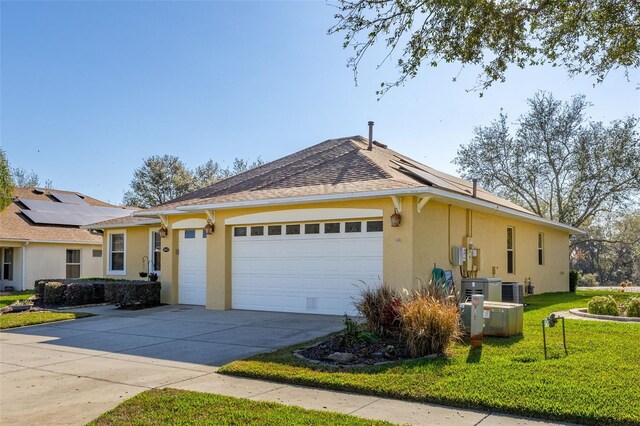 view of front facade with driveway, a front lawn, an attached garage, and stucco siding