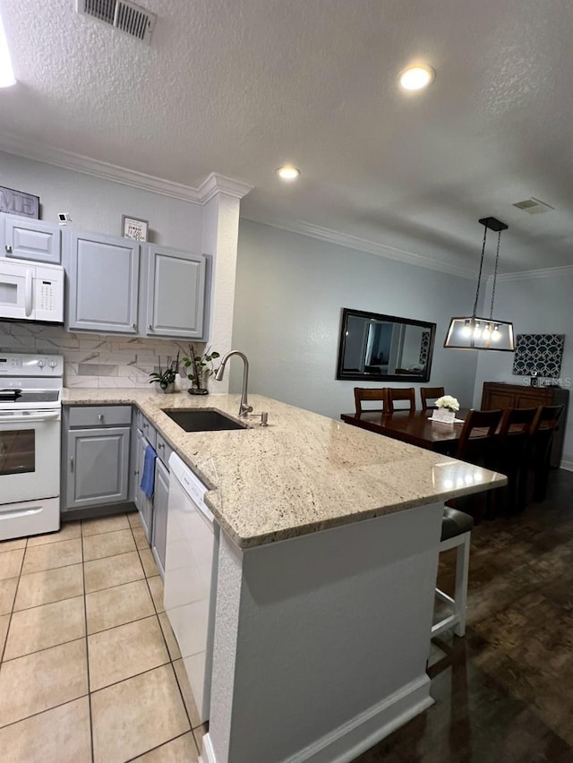 kitchen featuring gray cabinetry, white appliances, sink, ornamental molding, and kitchen peninsula