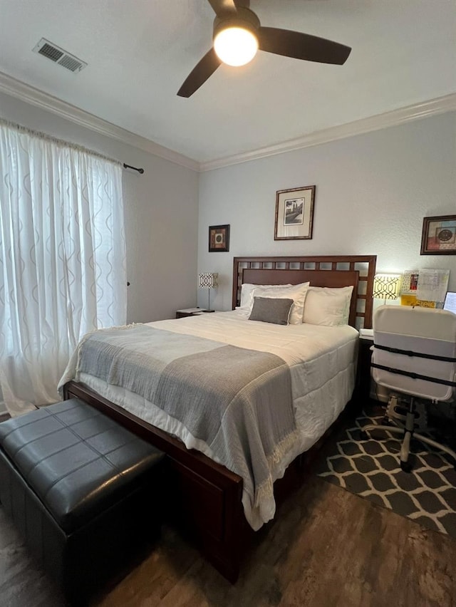 bedroom with ceiling fan, ornamental molding, and dark wood-type flooring