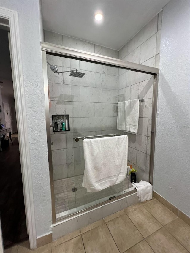 bathroom featuring tile patterned floors and a shower with shower door