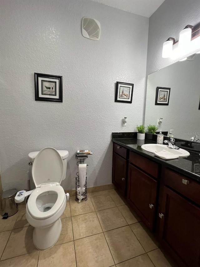 bathroom featuring tile patterned flooring, vanity, and toilet