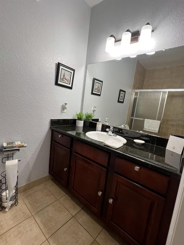 bathroom featuring tile patterned flooring, vanity, and walk in shower