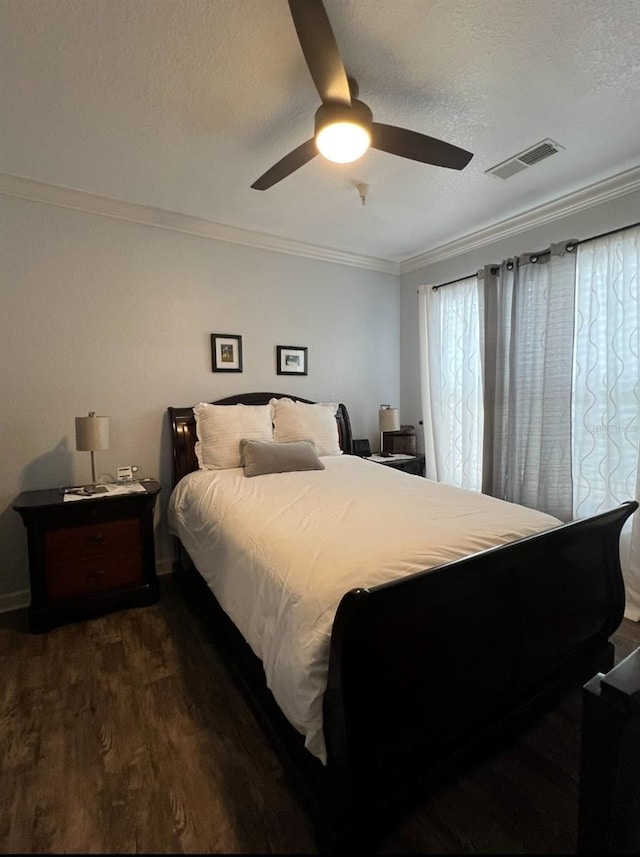 bedroom with dark hardwood / wood-style flooring, ceiling fan, crown molding, and a textured ceiling