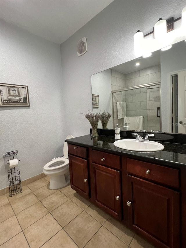 bathroom with tile patterned floors, vanity, toilet, and walk in shower