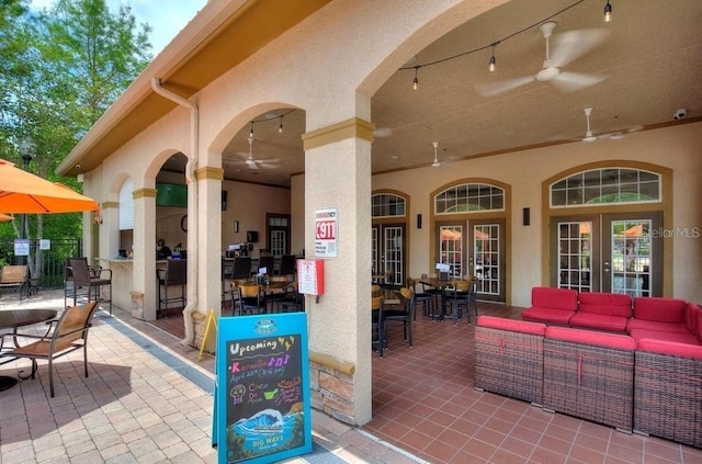 view of patio / terrace featuring ceiling fan, a bar, and an outdoor living space