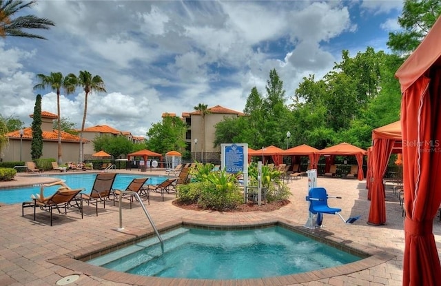 view of pool with a gazebo, a patio, and a hot tub