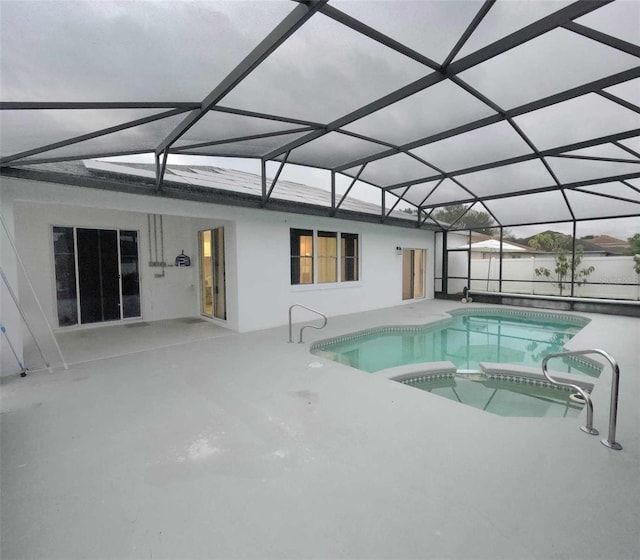 view of swimming pool with an in ground hot tub, a patio, and glass enclosure