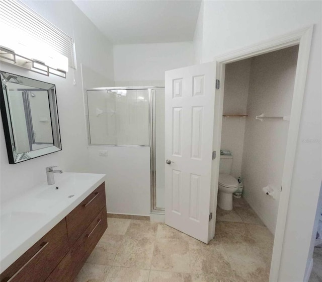 bathroom featuring vanity, toilet, and an enclosed shower