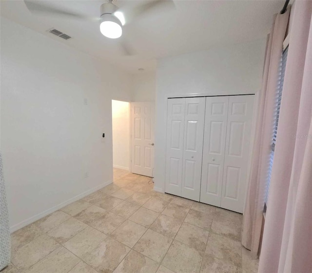 unfurnished bedroom featuring ceiling fan and a closet