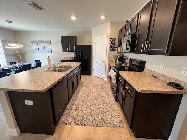 kitchen featuring light tile patterned floors, a kitchen island with sink, hanging light fixtures, black appliances, and sink