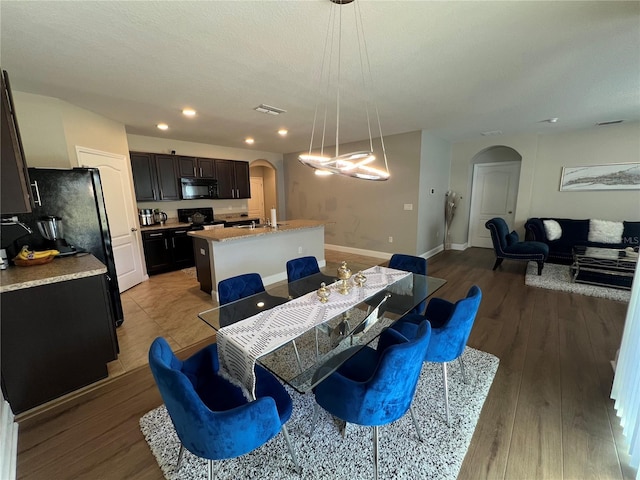 dining space featuring a textured ceiling, hardwood / wood-style flooring, and sink