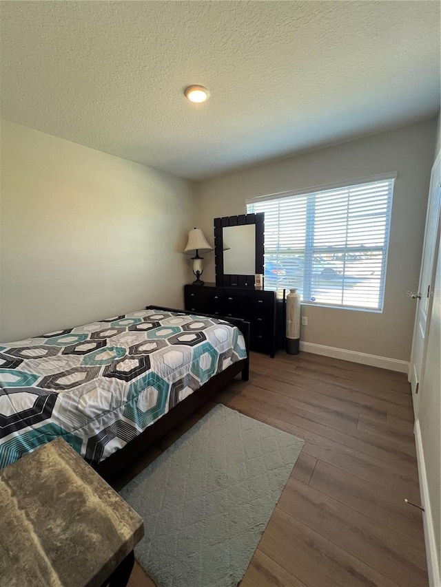 bedroom featuring a textured ceiling and hardwood / wood-style flooring