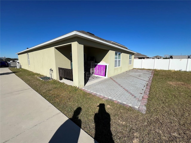 view of home's exterior with a patio area and a lawn