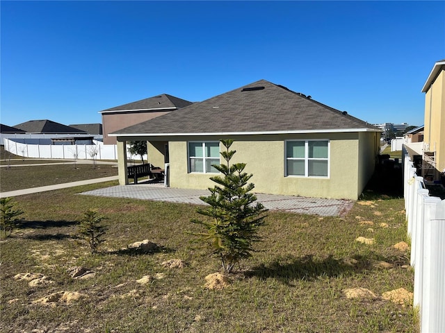 rear view of house with a yard and a patio