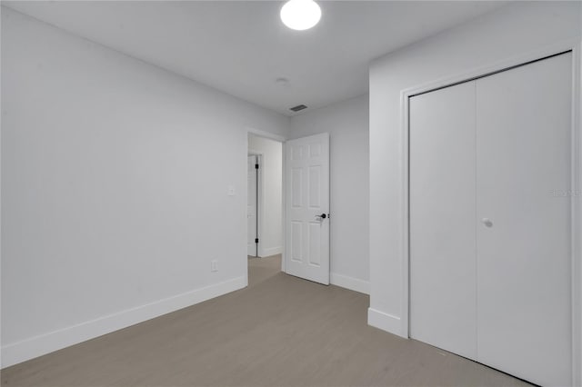 unfurnished bedroom with light hardwood / wood-style floors and a closet