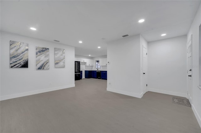 interior space featuring black refrigerator and hardwood / wood-style flooring