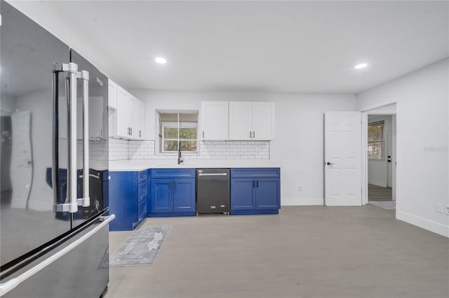 kitchen with white cabinetry, backsplash, high end refrigerator, blue cabinets, and stainless steel dishwasher