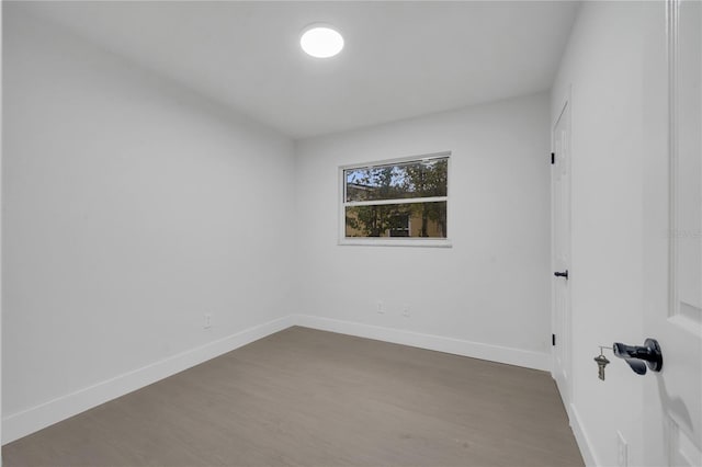 unfurnished room with dark wood-type flooring