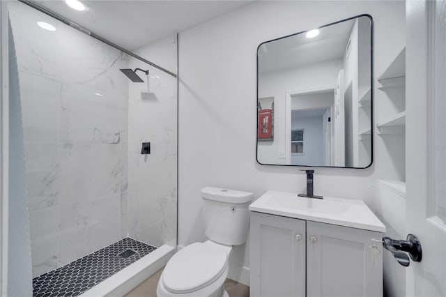 bathroom with vanity, toilet, and a tile shower