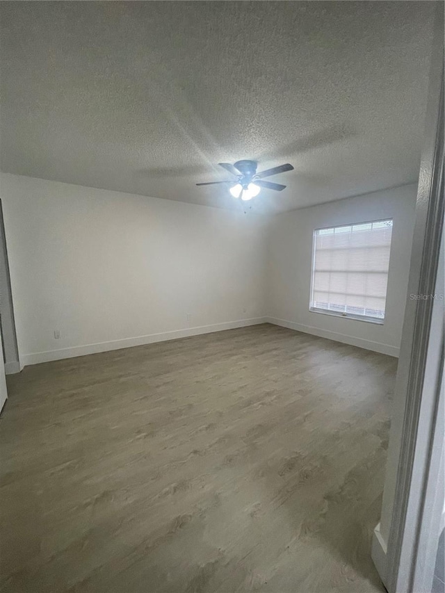 empty room with ceiling fan, a textured ceiling, and hardwood / wood-style flooring