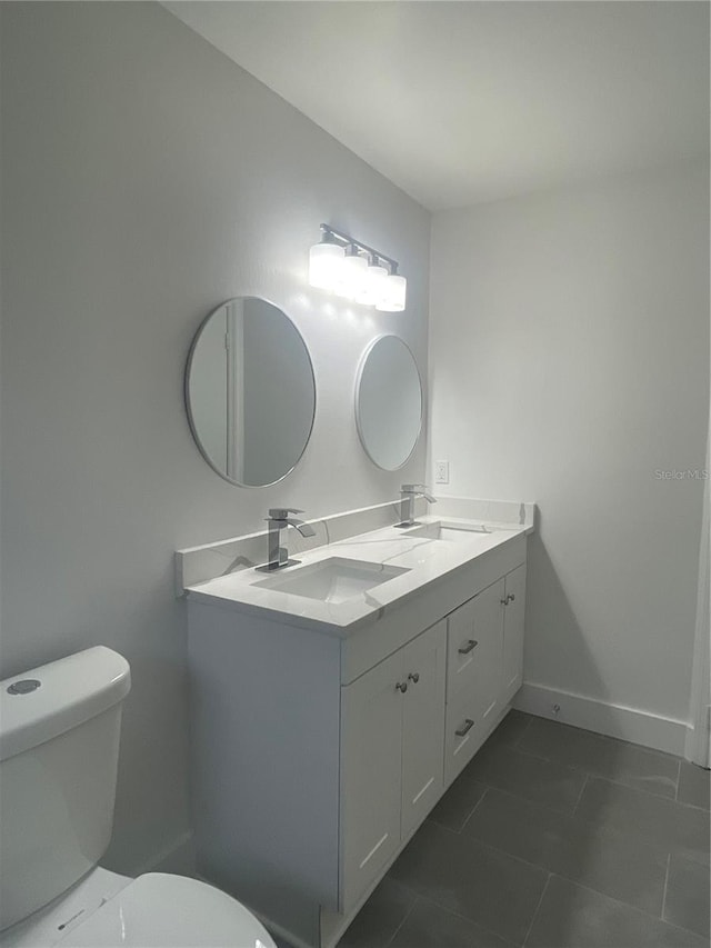 bathroom featuring tile patterned floors, vanity, and toilet