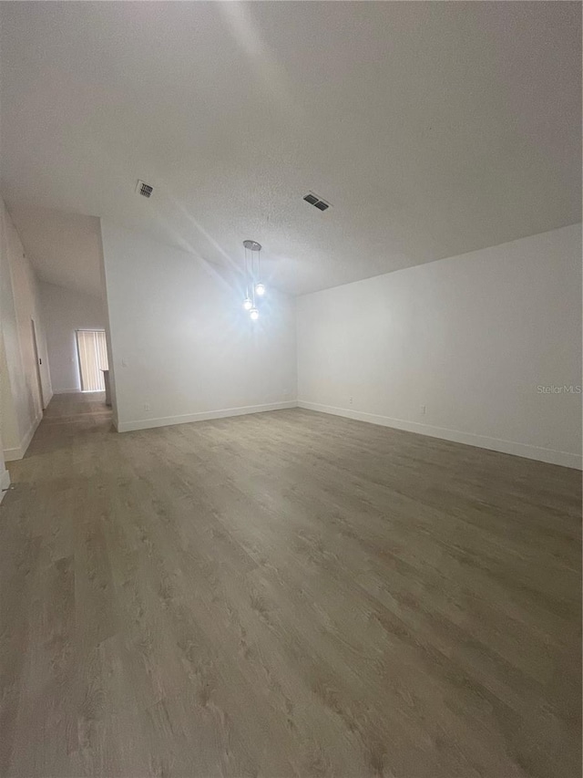 unfurnished room featuring hardwood / wood-style floors and a textured ceiling