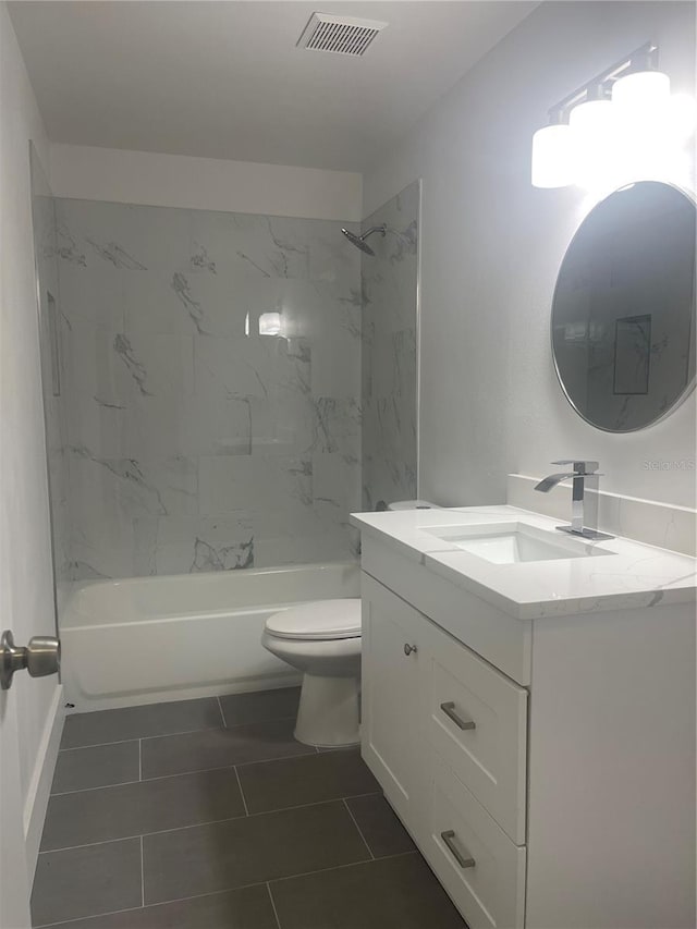 full bathroom featuring tile patterned floors, vanity, toilet, and tiled shower / bath