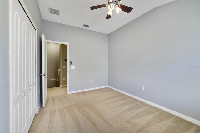 unfurnished bedroom with light colored carpet, visible vents, a closet, and baseboards