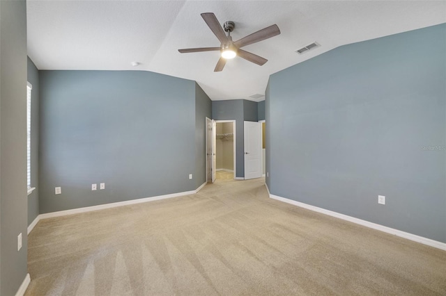 empty room featuring vaulted ceiling, baseboards, visible vents, and light carpet