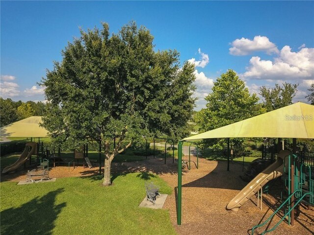 view of property's community featuring a lawn and playground community